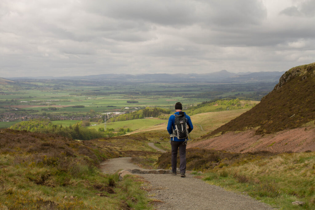 A man hillwalking in Scotland. Facing away from camera with rucksack on. 
