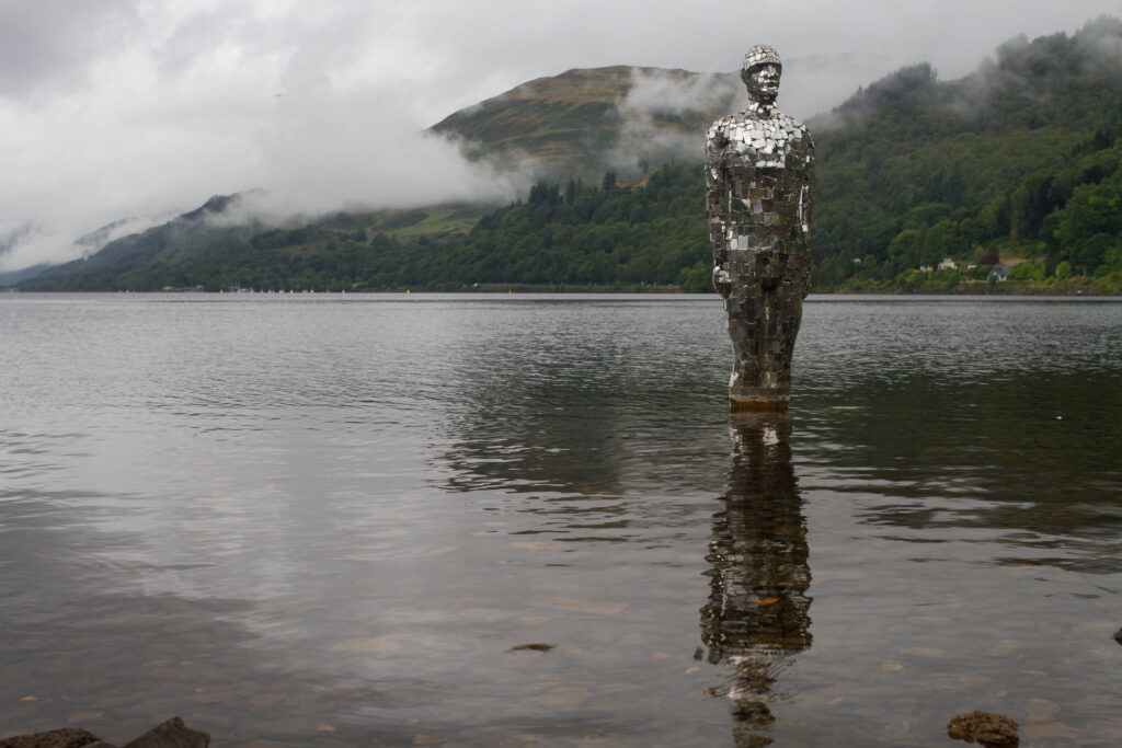 A mirrored mosaic statue in a loch in Scotland